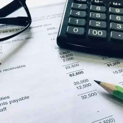 Balance sheet with calculator and glasses showing a financial review in Kenya – Zidika Consulting