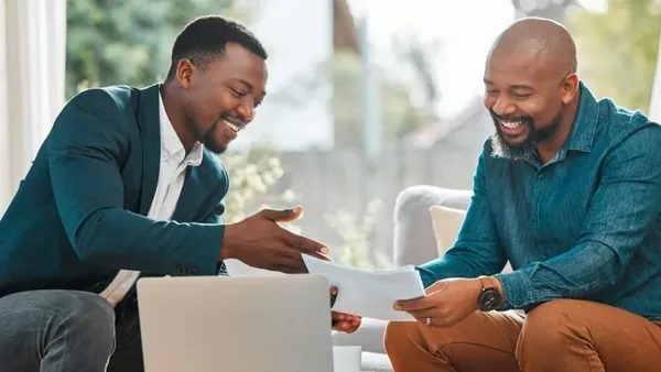 Two Nairobi businessmen discussing financial reports with support from Zidika Consulting, Kenya