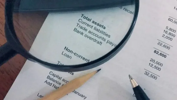 Financial statement on a desk with a pen and magnifying glass – Zidika Consulting Kenya