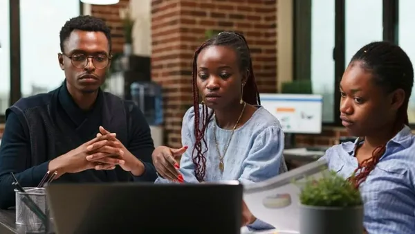 Three professionals in a Nairobi office reviewing outsourced accounting data – Zidika Consulting, Kenya