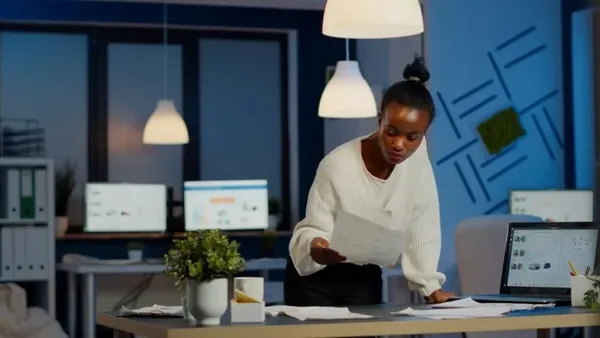 Woman reviewing a paper next to a laptop in a Nairobi office – Zidika Consulting Kenya