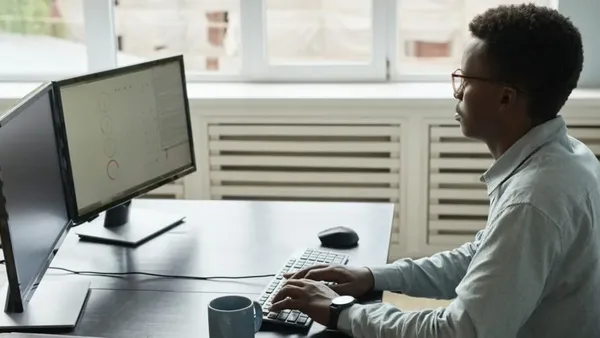 Freelancer in Nairobi using dual screens to file taxes – Zidika Consulting, Kenya