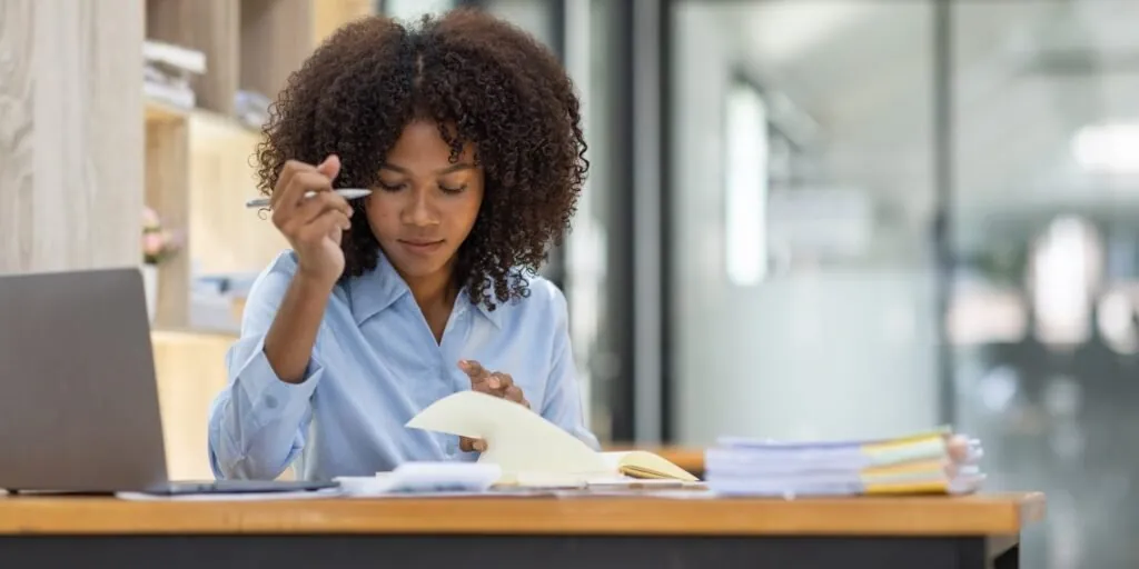 Kenyan business owner reviewing organized compliance records at a desk
